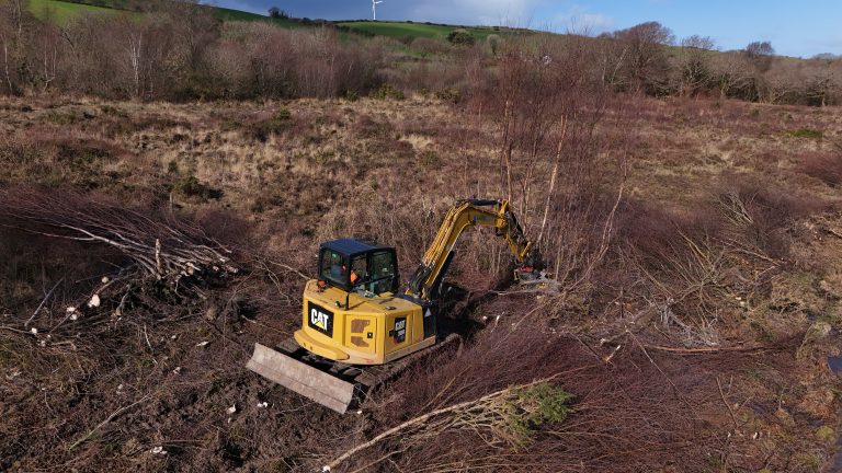 Excavator piling woody debris