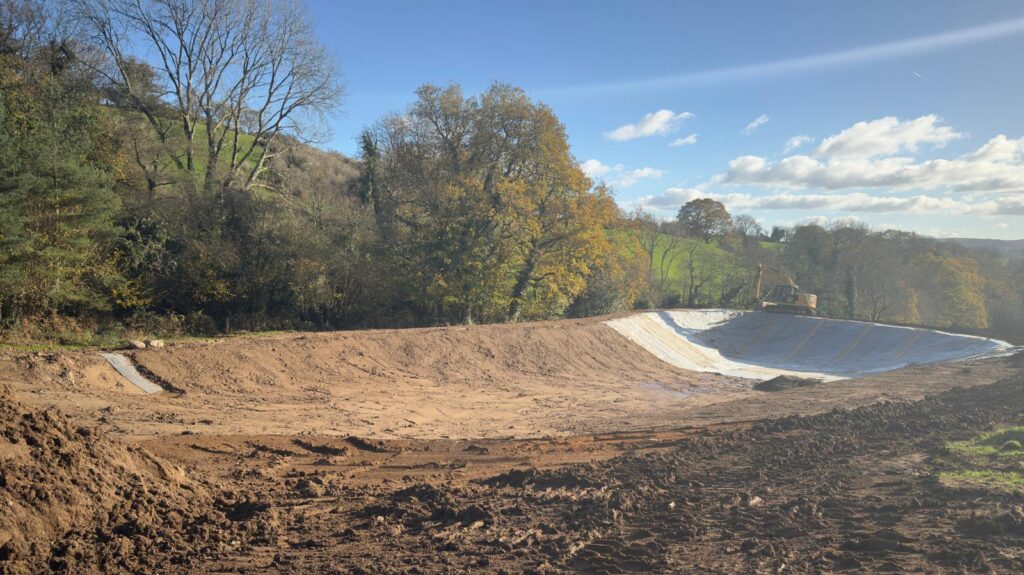 Lined pond showing backfilling on top of the liner